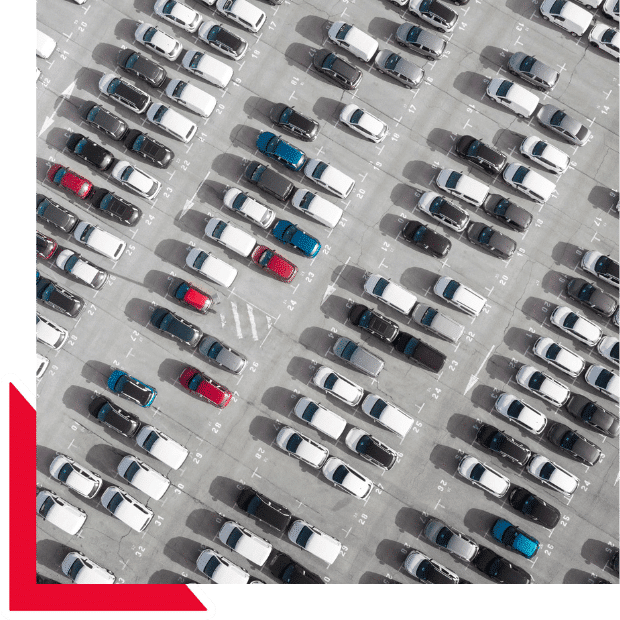 Vista aérea de un estacionamiento con decenas de autos alineados en filas, representando importar autos sin titulo